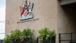 The country's coat of arms hangs on the facade of a government building in Port-of-Spain, Trinidad and Tobago, Tuesday, Aug. 20, 2024. Prime Minister Keith Rowley announced on Sunday, Aug. 18, 2024, that the country is redrawing the island's coat of arms to remove references to European colonization, replacing Christopher Columbus' three ships with the steelpan, a popular percussion instrument. (AP Photo/Ash Allen)